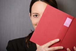 Frau lugt hinter Buch hervor | © contrastwerkstatt - adobestock